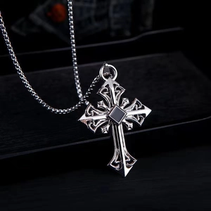 Macro shot of silver cross necklace with a square black gemstone in a vintage hip hop style