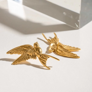 Close-up of gold stainless steel dove earrings showing detailed feather texture