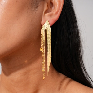 Close-up of 18k gold plated long tassel chain earrings worn by a female model