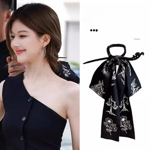 Detail of a Chinese style black satin hair ribbon with floral embroidery and matching hair pin
