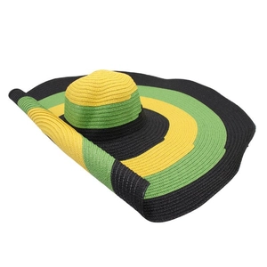 Detail of wide brim straw sun hat featuring bold yellow, green, and black striped patterns