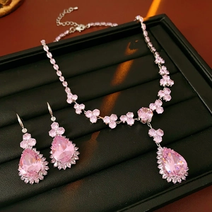 Dettaglio della collana e degli orecchini in cristallo rosa su vassoio in pelle nera