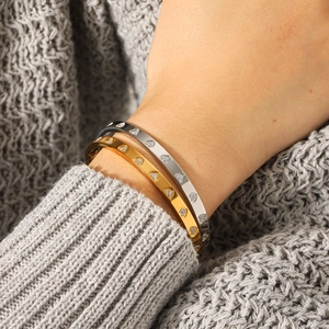 Bracelets cœur en acier inoxydable plaqué or 18K avec strass sur un poignet féminin