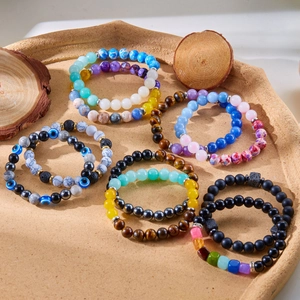 Natural lava stone and tiger eye beaded bracelet set with devil eye charms in a tray