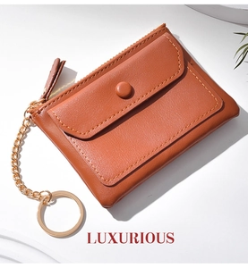 Macro detail of brown leather mini coin purse with gold zipper and keychain ring