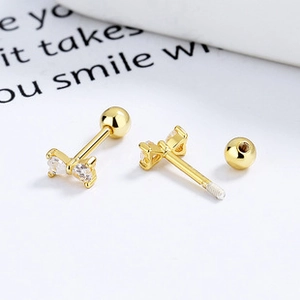 Macro shot of gold bow stud earring with clear zircon stones and screw back closure