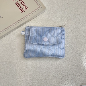 Macro shot of blue striped quilted coin purse with heart texture and snap button closure