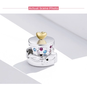 Detailed view of s925 silver cake charm with colorful zircons and golden heart accent