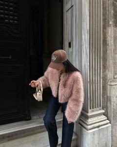 Stile street di una donna con una giacca corta rosa in finta pelliccia all'aperto