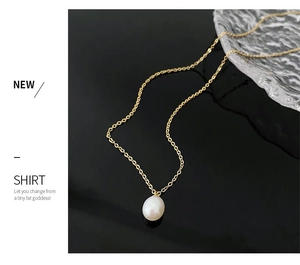Macro shot of a single natural pearl pendant on a thin gold titanium chain necklace