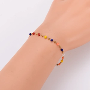 Minimalist stainless steel bracelet with colorful square beads on a model's wrist