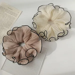 Elegant pleated mesh scrunchies with black edges in cream and champagne colors