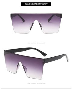 Detail of oversized black square sunglasses with gradient grey lenses and frameless design