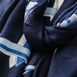 Close-up of navy blue scarf with geometric ribbon pattern and soft knit texture