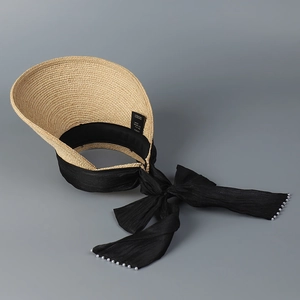 Straw open-top sun hat for women featuring a black fabric bow and elegant pearl accents