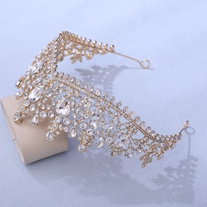 Macro view of gold bridal crown with shimmering rhinestones and crystal leaf motifs