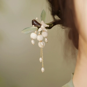 Détail d'une épingle à cheveux muguet faite main avec perles et feuilles vertes