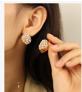 Close-up of 18K gold plated cluster earrings with white pearls worn on ear