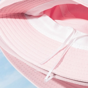 Detail view of the pink bucket hat interior showing the white adjustable drawcord and fabric texture