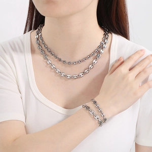 Close-up of silver coffee bean link necklace and bracelet set on model for stylish look