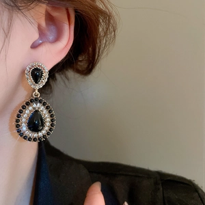 Detail of vintage dark style teardrop earrings with black gems and sparkling rhinestones