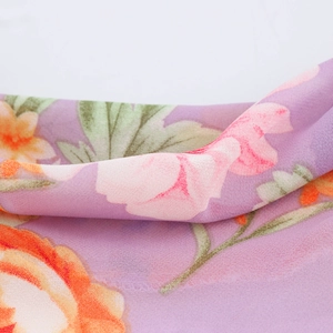 Close-up of purple floral sleeveless dress fabric featuring soft chiffon with flower print