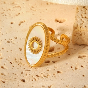 Detailed shot of gold stainless steel sunburst ring with white shell inlay on stone