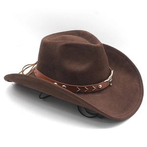 Détail d'un chapeau de cowboy marron avec badge tête de taureau et lanière en cuir clouté