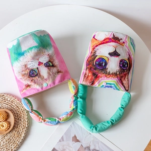 Cartoon cat print padded canvas bucket bag with ruffled top handle on white table