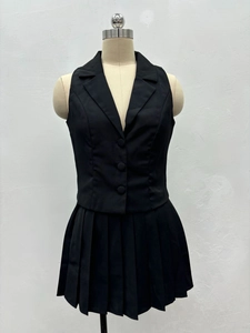 Vue de face de l'ensemble noir deux pièces avec gilet sans manches et mini-jupe plissée