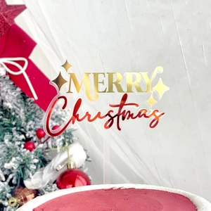 Close-up of gold and red Merry Christmas acrylic cake topper with star details