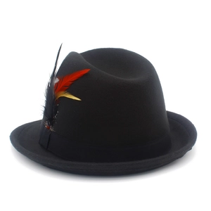 Close-up of black wool fedora hat featuring vibrant red and yellow feather detail