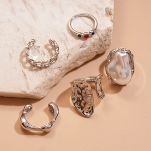 Detailed close-up of 5-piece silver ring set with colored stones and baroque pearl