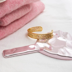 Gros plan détaillé du bracelet jonc doré en acier inoxydable avec motif dentelle chic