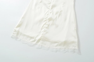 Detailansicht des glatten weißen Satin-Kleidsaums mit eleganter Spitzenborte