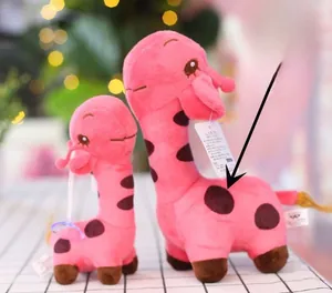 Detail of pink giraffe plush set with spots in large and small sizes on checkered cloth