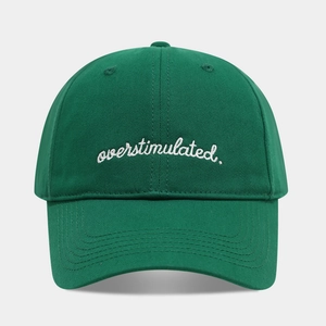 Close-up of white letter embroidery on a dark green cotton twill baseball cap