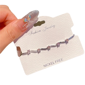 Elegant wavy silver bracelet with pink zircon stones for women on white background