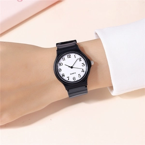Wrist shot of a minimalist quartz watch with white dial and black rubber strap