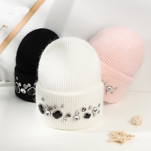 Detail of white, black, and pink angora rabbit fur knit beanies with rhinestone decor