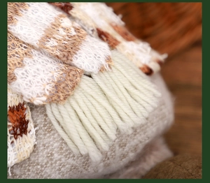 Makroaufnahme von gestrickten Streifenmustern und Quasten an Weihnachtsfiguren