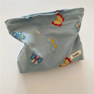 Light blue fabric makeup bag with colorful butterfly embroidery and a secure zipper