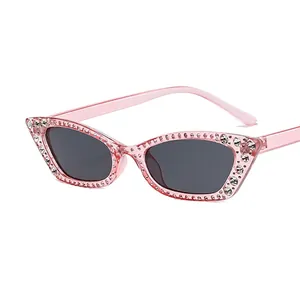 Pink cat-eye sunglasses with rhinestone edges and gray lenses in a stylish retro design