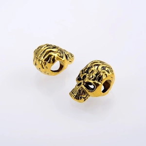 Antique gold skull beads for jewelry making with vintage skeleton detail and hole