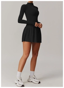 Detail of a black long sleeve zip-up sports top and pleated tennis skirt set for women