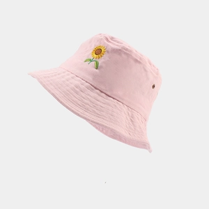 Détail d'un bob en coton rose avec broderie de tournesol et œillet métallique