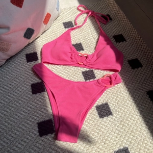 Detail of pink waffle knit bikini featuring heart-shaped rings and textured fabric