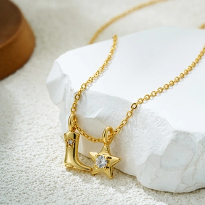 Macro shot of 18K gold boots pendant with zircon star on vintage steel necklace