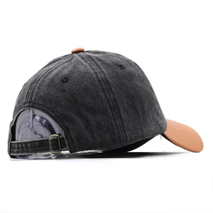 Detail view of the vintage washed denim baseball cap with brown brim and metal buckle