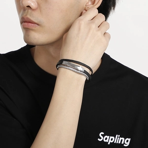 Close-up of multilayer men's leather bracelet with silver metal chain and plaque